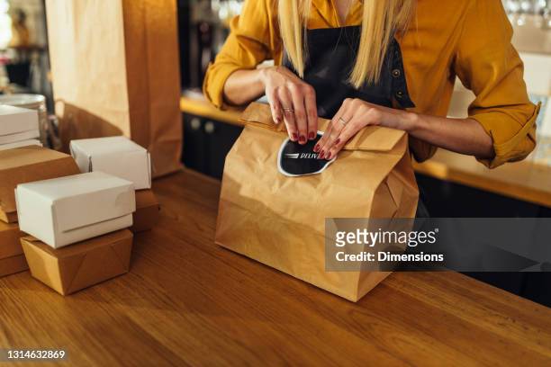 close up of woman packing food for delivery - fast food stock pictures, royalty-free photos & images