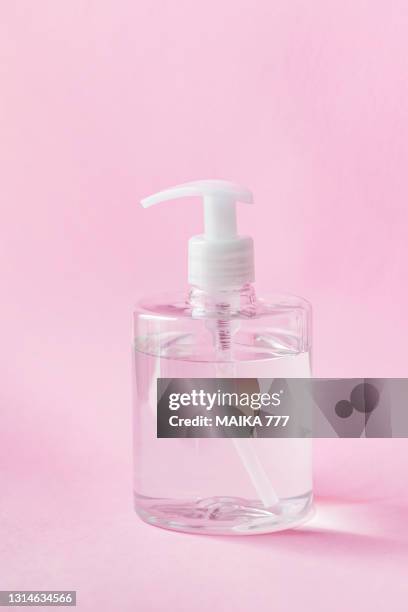 pump dispenser bottle of hydroalcoholic gel hand sanitizer to prevent covid-19 virus on pink background - tape dispenser stock pictures, royalty-free photos & images