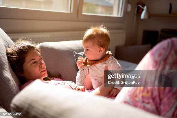 tired mother holding her baby son - tired stock pictures, royalty-free photos & images