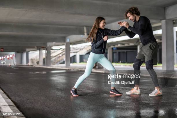 joven pareja atlética practicando habilidades de boxeo. - defensa propia fotografías e imágenes de stock