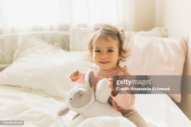 adorable baby girl wake up and smiling  in sunny nursery. - baby girls stock pictures, royalty-free photos & images