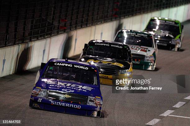 James Buescher, driver of the Exide Batteries Chevrolet, leads Timothy Peters, driver of the NTB/Service Central Toyota, and Kevin Harvick, driver of...