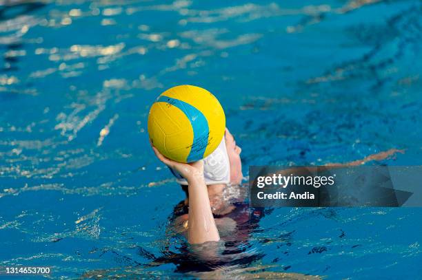 Yellow, blue and pink Mikasa water polo ball in the hands of an athlete.