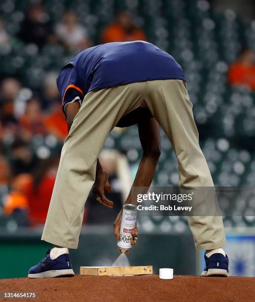 Houston Astros head groundskeeper Willie Berry tends the mound before a game with the Los Angeles Angels at Minute Maid Park on April 23, 2021 in...