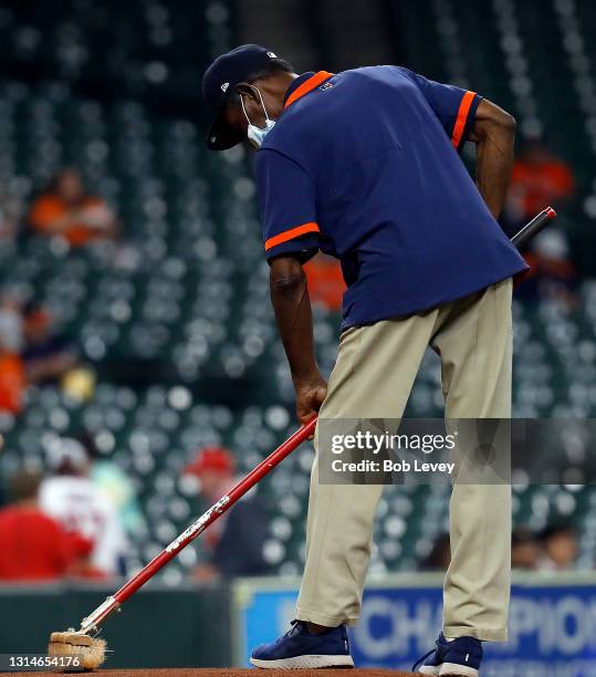 Houston Astros head groundskeeper Willie Berry tends the mound before a game with the Los Angeles Angels at Minute Maid Park on April 23, 2021 in...