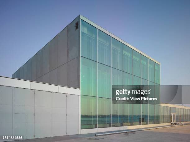 Exterior facade with reflection of lake Weerwater in glazing. De Kunstlinie Cultural Centre And Theatre, Almere, Netherlands. Architect: SANAA, 2007.