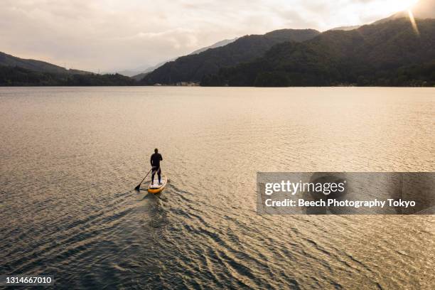 paddle boarding (sup) alone in a lake - paddleboard stockfoto's en -beelden