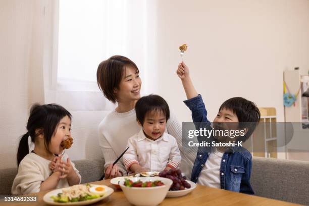 young mother with three children eating food in dining room - camel meat stock pictures, royalty-free photos & images