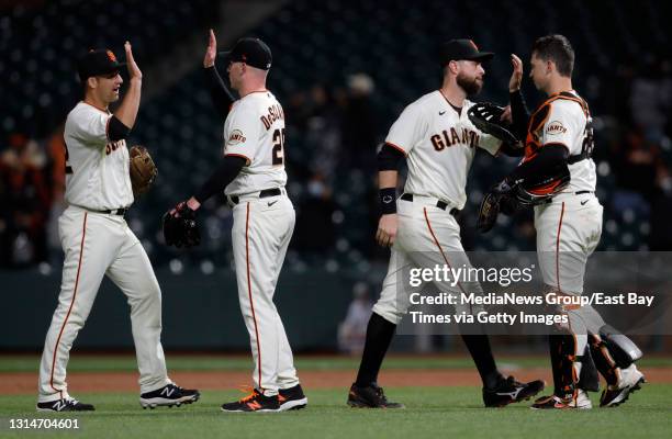 San Francisco Giants' Alex Dickerson, #12 starting pitcher Anthony DeSclafani, #26 Brandon Belt and catcher Buster Posey celebrate their 12-0 win...