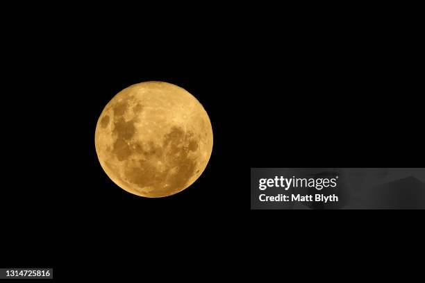 The moon is seen in the sky towards the east on April 27, 2021 in Sydney, Australia. The pink super moon is the first of two super moons which will...