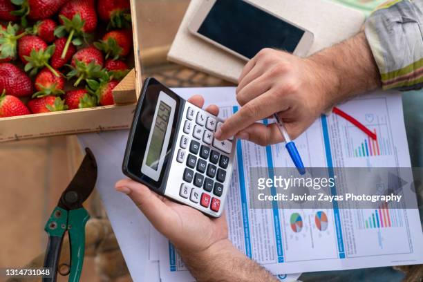 farmer checking his finances and counting the numbers - worried farmer stock pictures, royalty-free photos & images