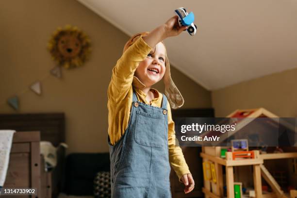 söt liten pojke leker med sin leksak i sitt rum - modellflygplan bildbanksfoton och bilder