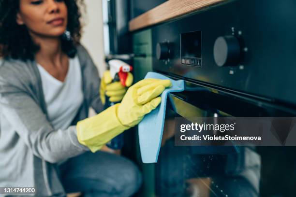 mujer limpiando superficie en casa. - horno fotografías e imágenes de stock