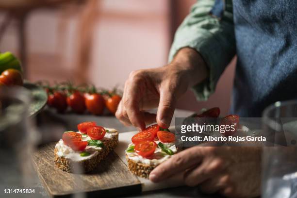 man with three cheese and tomatoes toast - canapé 個照片及圖片檔