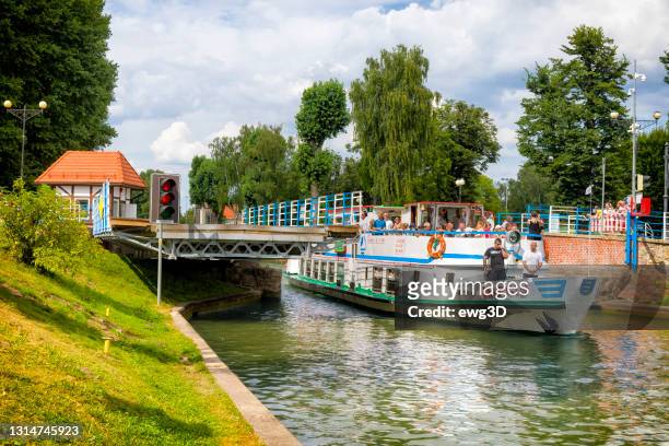holidays in poland - tourboat passes through the luczański channel in gizycko - gizycko stock pictures, royalty-free photos & images