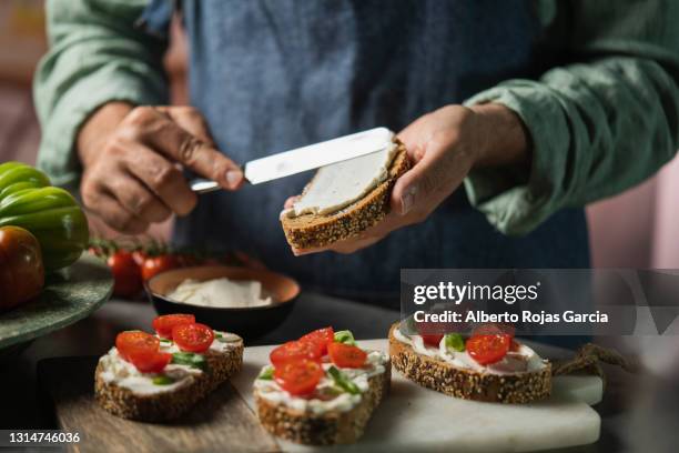 a man with a blue apron prepare a cheese toast - baguette white stock pictures, royalty-free photos & images
