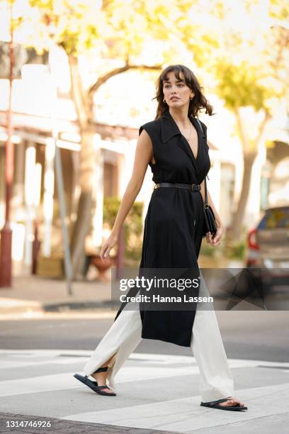 Sarah Stephens is seen wearing black long Bassike top, white pants and shoes, Status Anxiety belt and YSL bag on April 27, 2021 in Sydney, Australia.