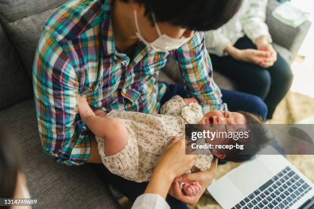 junge ärztin zu hause besucht ihre babypatientin und überprüft den gesundheitszustand - bronchialbaum stock-fotos und bilder