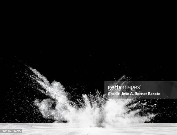 impact and explosion of white dust and smoke particles on a black background. - colourful studio shots stockfoto's en -beelden