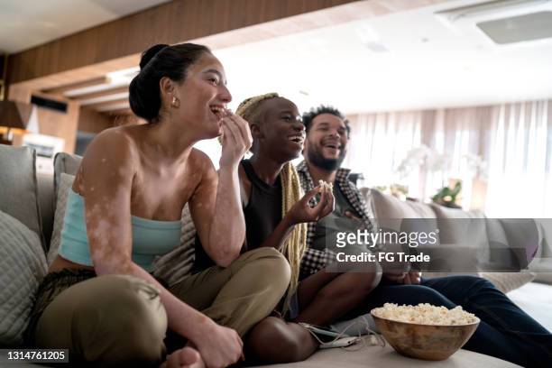 freunde schauen gemeinsam zu hause fern - watching stock-fotos und bilder