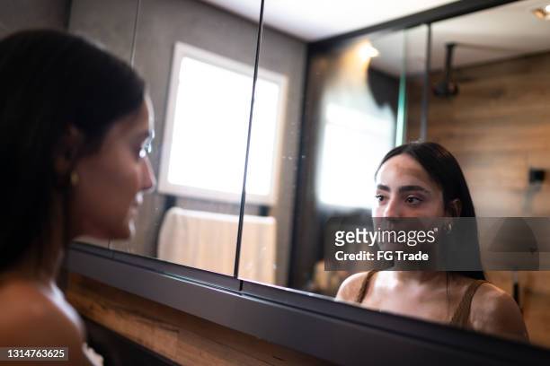 ung kvinna med vitiligo tittar i spegeln hemma - body conscious bildbanksfoton och bilder