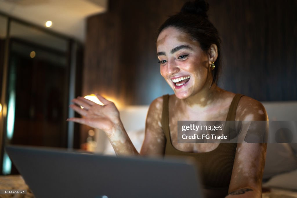 Junge Frau macht einen Videoanruf auf Laptop zu Hause