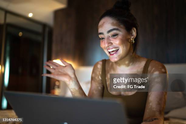 young woman doing a video call on laptop at home - misses vlog stock pictures, royalty-free photos & images