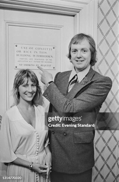 English lyricist Tim Rice marries Jan McIntosh at Kensington Register Office in London, UK, 19th August 1974. He is pointing to a sign which...