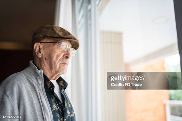 senior man contemplating at home - fragile stock pictures, royalty-free photos & images