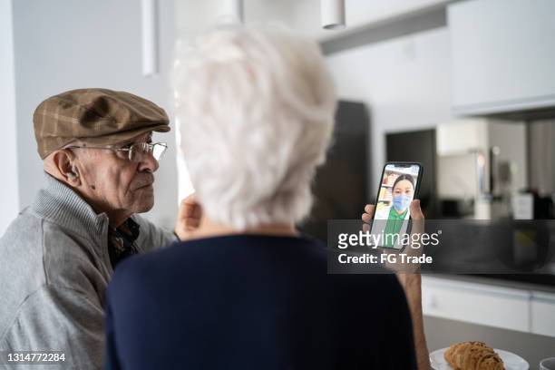 senior couple on a telemedicine call with doctor - telemedicine patient stock pictures, royalty-free photos & images