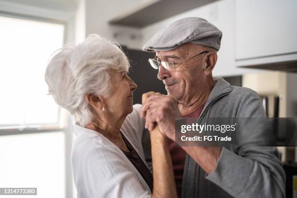 pareja mayor bailando en casa - baile fotografías e imágenes de stock