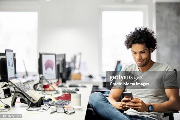 male entrepreneur using mobile phone in office - office telephone stock pictures, royalty-free photos & images