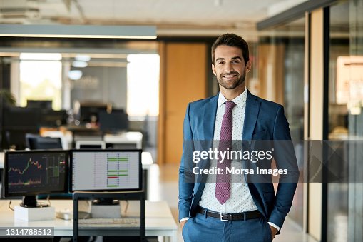 Happy Businessman With Hands In Pockets At Office Happy Businessman With Hands In Pockets At Office