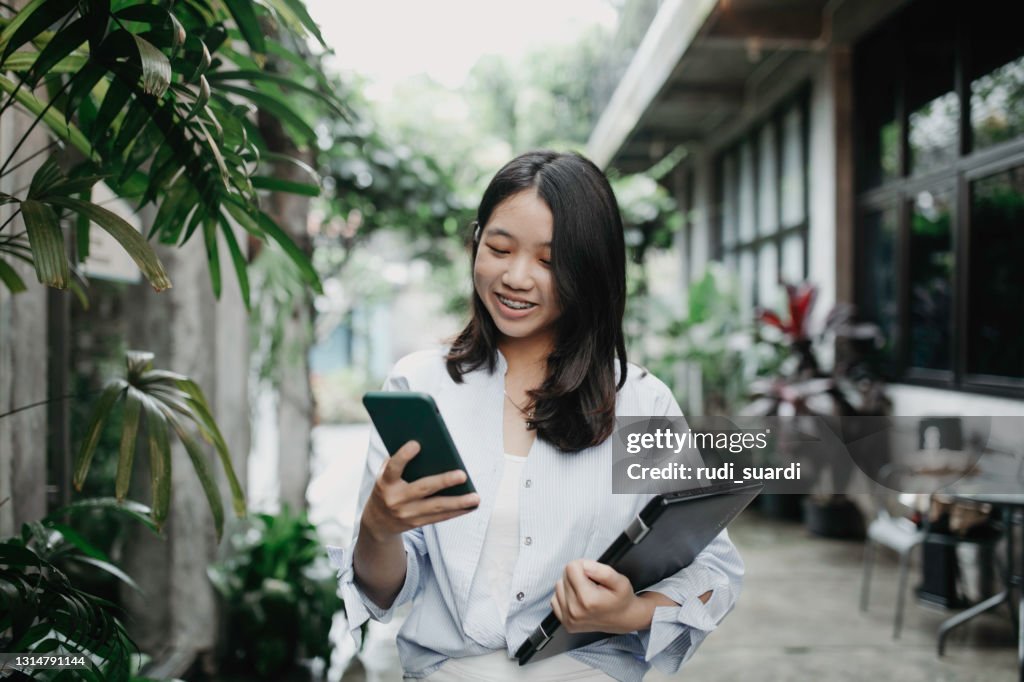 College Student Standing at Entrance to University Building