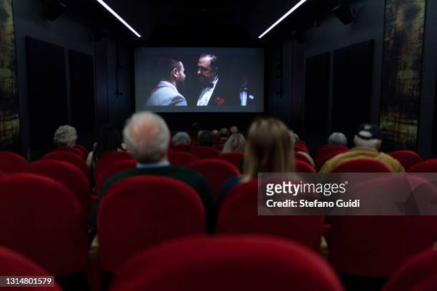 People watch a movie at Cinema Centrale on April 27, 2021 in Turin, Italy. Cafes, bars, restaurants, cinemas and concert halls will partially reopen...