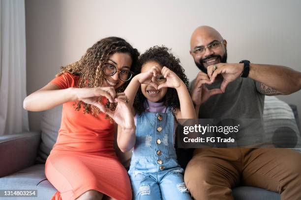 retrato de uma família fazendo forma de coração com as mãos em casa - mother daughter webcam - fotografias e filmes do acervo