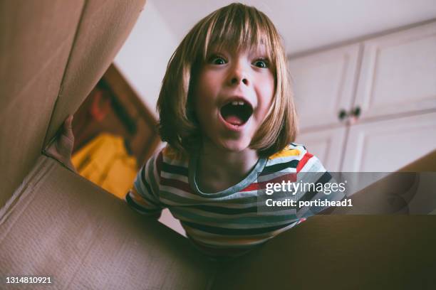 portrait of happy boy opening delivery box at home - inside of box stock pictures, royalty-free photos & images