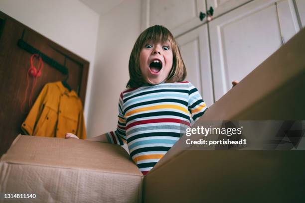 gelukkige jongen die leveringsdoos thuis opent - boy in a box stockfoto's en -beelden