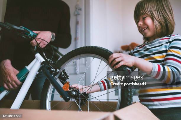 gelukkige jongen die een nieuwe fiets na online het winkelen uitpakt - boy in a box stockfoto's en -beelden