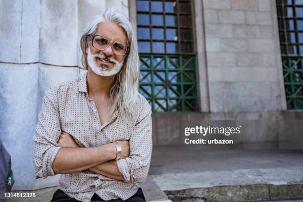 mature gray man with crossed arms - long gray hair stock pictures, royalty-free photos & images