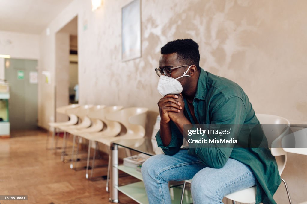 Worried African American patient sitting in the waiting room at the hospital