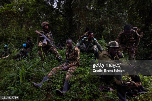 Congolese Army Soldiers and UN forces rest after inspecting an ambush site where an hour previously ADF fundamentalist rebels attacked two vehicles...