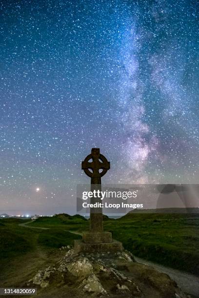 The Milky Way and night sky over the Celtic Cross at Llanddwyn Island on Anglesey.