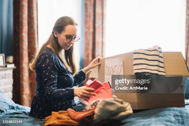 women choosing clothes to donate - decluttering stock pictures, royalty-free photos & images