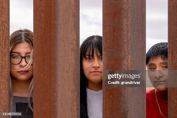 group of mexican people looking through the international border wall between chihuahua mexico and texas, usa - international organisation for migration stock pictures, royalty-free photos & images