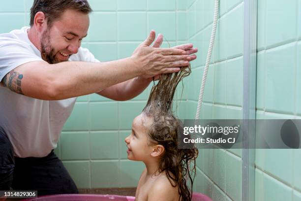 vater, der seiner tochter während des bades die haare seifen. - neue männlichkeit stock-fotos und bilder