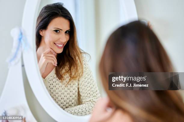 woman looking in the mirror at home - vanity table stock pictures, royalty-free photos & images