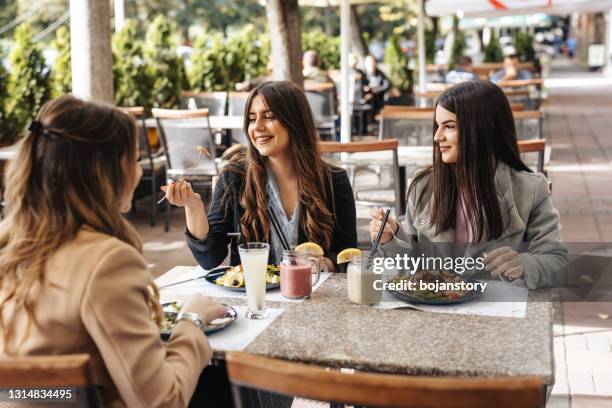 beautiful ladies in outdoor restaurant - restaurant patio dining stock pictures, royalty-free photos & images