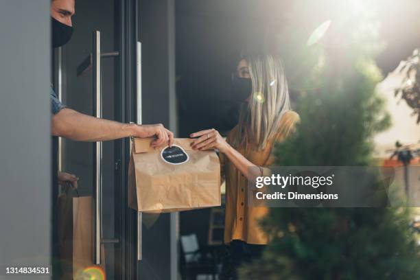 customer pick up takeout food order from waiter - picking up food stock pictures, royalty-free photos & images