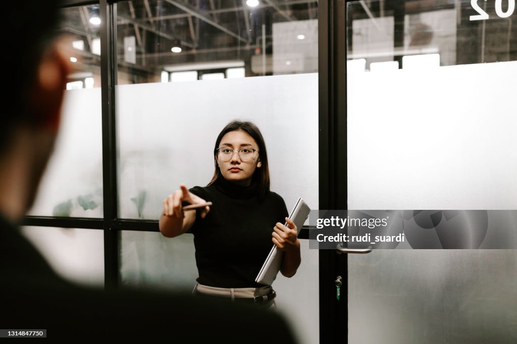 Businesswoman pointing at employee